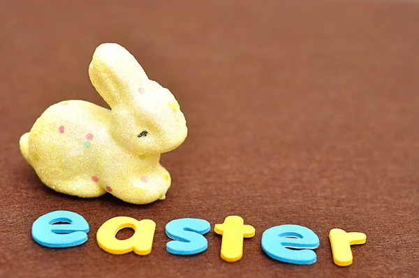 A palavra Páscoa com um coelho amarelo — Fotografia de Stock