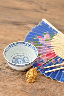 Çene kase, yemek çubukları, mavi el fan ve Buda heykelcik