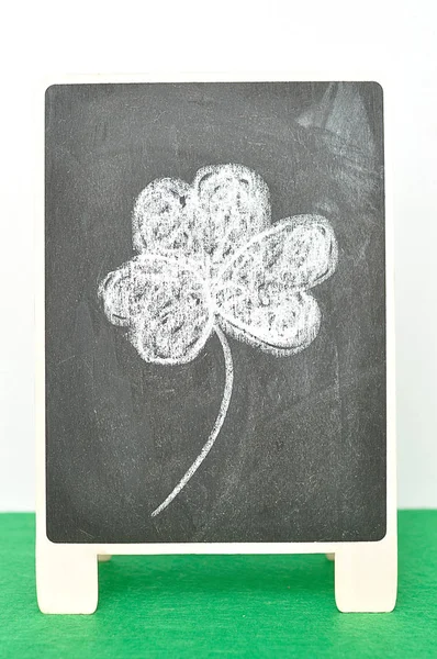 Un tableau noir avec un trèfle à quatre feuilles un symbole pour Saint Patrick — Photo