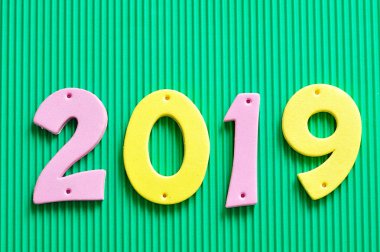yeşil bir arka plan üzerine pembe ve sarı rakamlarla 2019
