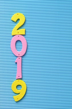 mavi bir arka plan üzerine pembe ve sarı rakamlarla 2019