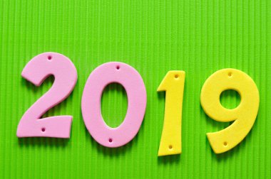 yeşil bir arka plan üzerine pembe ve sarı rakamlarla 2019