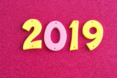 pembe bir arka plan üzerine pembe ve sarı rakamlarla 2019