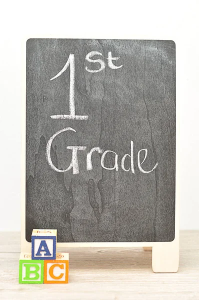 Un tableau noir avec les mots 1ère année avec des blocs d'alphabet ABC — Photo