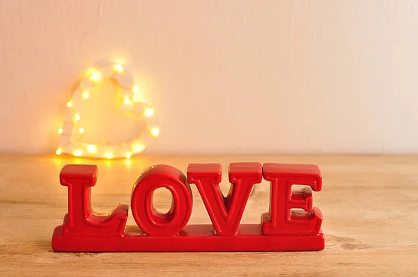 La palabra amor en rojo con una forma de corazón desenfocada —  Fotos de Stock