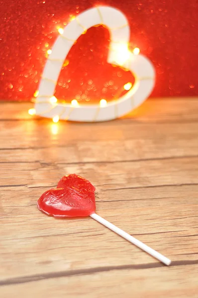 軽い心臓の形で赤背景に分離した赤いハート形ロリポップ — ストック写真