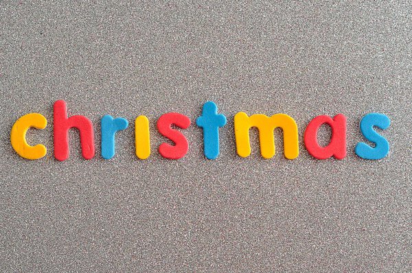 Рождество в красочных письмах на серебряном фоне
