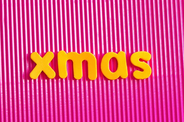 The word Xmas in yellow letters on a pink background — Stock Photo, Image