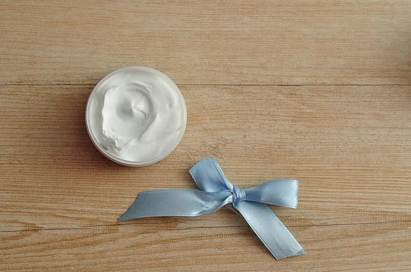 Un pot de lotion corporelle blanche affichée avec un arc bleu — Photo