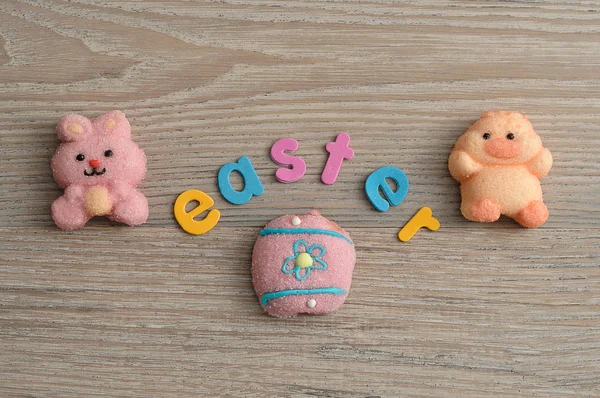 Een roze konijntje vorm marshmallow, een kip vorm marshmallow en een ei met het woord Pasen — Stockfoto