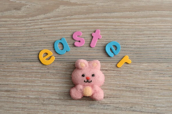 Un malvavisco con forma de conejito rosa con la palabra Pascua — Foto de Stock
