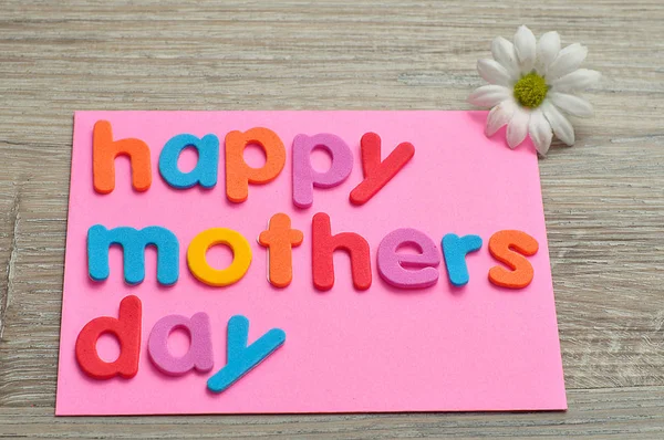 Joyeuse fête des mères sur une note rose avec une marguerite blanche — Photo