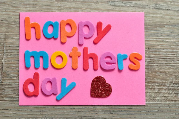 Joyeuse fête des mères sur une note rose avec un cœur rouge — Photo