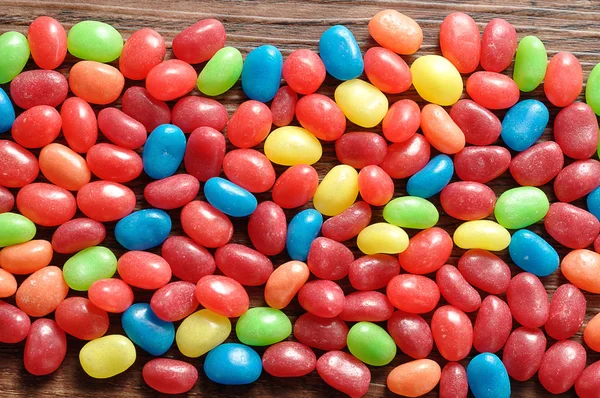 A variety of colors jelly beans on a wooden background — Stock Photo, Image