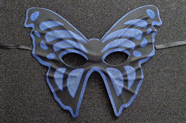 A blue and black mask in the shape of a butterfly — Stock Photo, Image