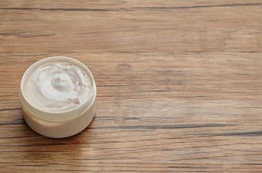 Bir tüp diş ahşap arka plan üzerinde beyaz vücut losyonu