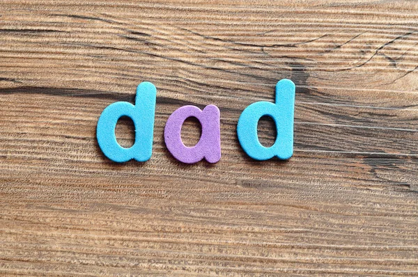 The word dad on a wooden background — Stock Photo, Image