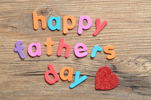 Giorno di padri felice su uno sfondo di legno con un cuore rosso — Foto Stock