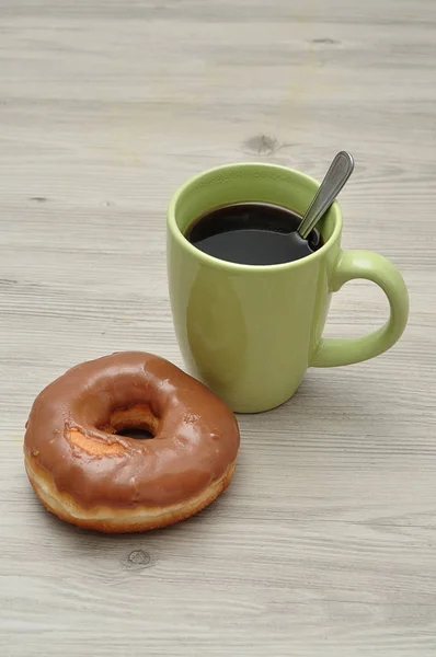 O gogoașă cu o cană verde de cafea — Fotografie, imagine de stoc