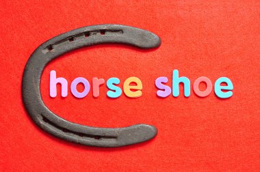 Kelime at ayakkabı kırmızı arka plan ile bir at nalı