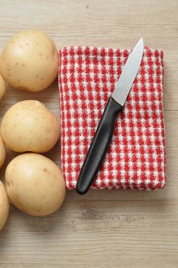 Patates, bir bıçak ve kareli kırmızı Bulaşık bezi