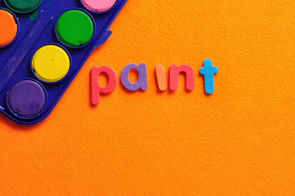 Pintar con la palabra pintura sobre un fondo naranja — Foto de Stock