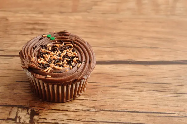 Um cupcake de chocolate decorado com aspersores de chocolate — Fotografia de Stock