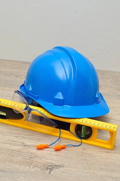 A hardhat, level, safety spectacles and earplugs — Stock Photo, Image