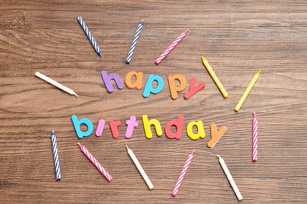 Happy birthday in colorful letters with a collection of birthday candles