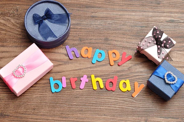 Happy birthday in colorful letters with a variety of gift