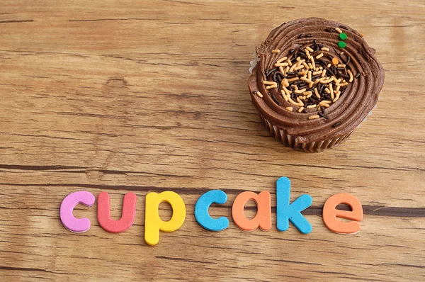 A palavra cupcake exibida com um cupcake — Fotografia de Stock