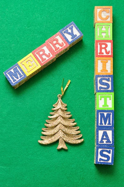 Ein goldener Weihnachtsbaum und die Worte Frohe Weihnachten — Stockfoto