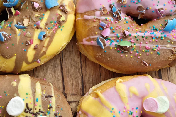 Donuts decorados em um fundo de madeira — Fotografia de Stock
