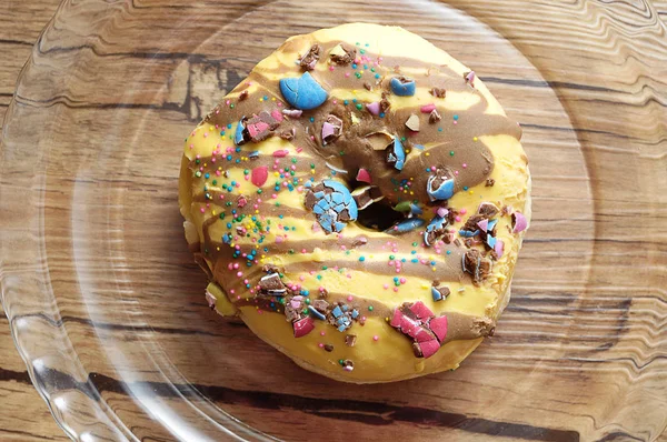 Um donut decorado em uma placa de vidro — Fotografia de Stock