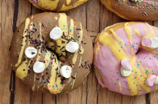 Donuts decorados em um fundo de madeira — Fotografia de Stock