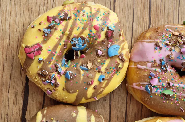 Decorated doughnuts on a wooden background — Stock Photo, Image