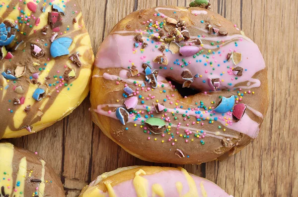 Donuts decorados em um fundo de madeira — Fotografia de Stock