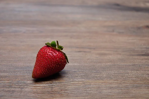 A strawberry on a wooden background — Stock Photo, Image