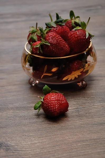 A bowl of strawberries on a wooden background — Stock Photo, Image