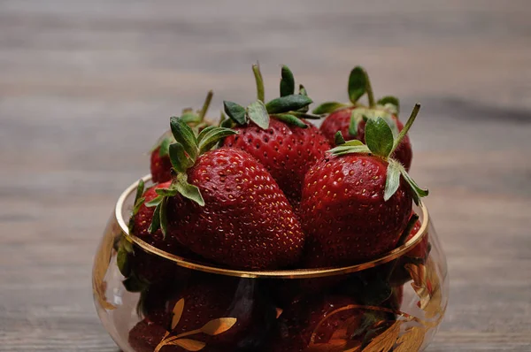 A bowl of strawberries on a wooden background — Stock Photo, Image