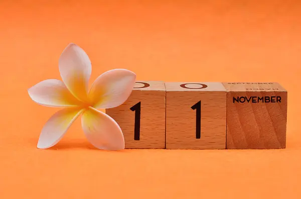 Listopada Drewnianych Blokach Kwiatem Frangipani Pomarańczowym Tle — Zdjęcie stockowe