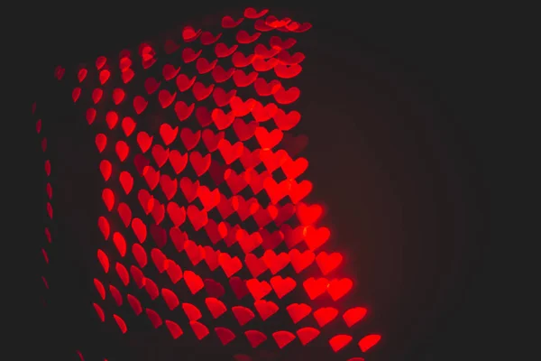 Красные сердца боке в темной текстуре — стоковое фото
