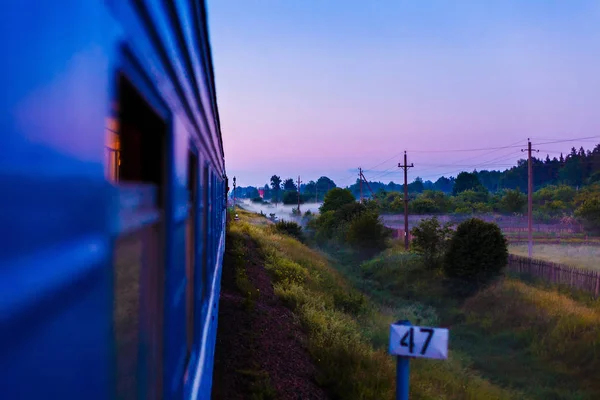 Σιδηροδρομικές τρένο κινείται κατά μήκος το πανέμορφο τοπίο στο ηλιοβασίλεμα σε άθροισμα — Φωτογραφία Αρχείου