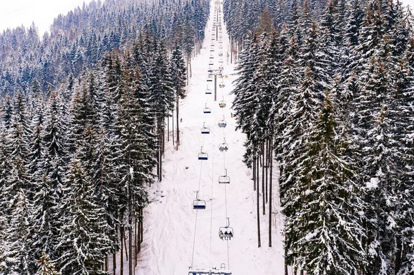 İnsanlar yoğun kar yağışından sonra dağlarda kayak yapmak için teleferik kullanıyorlar.