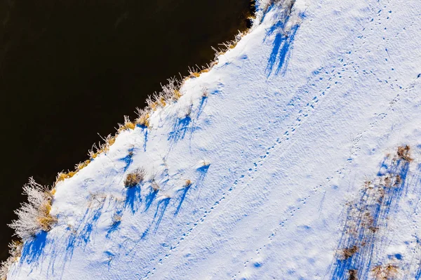 Neve na costa perto do rio, paisagem aérea. Dia ensolarado na área rural. Conceito de dia brilhante — Fotografia de Stock