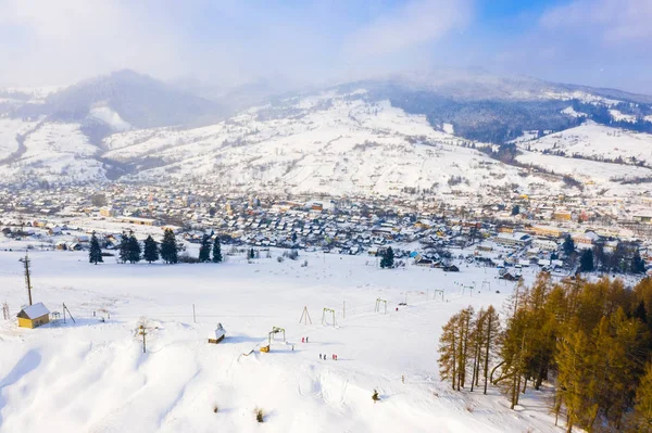Aldeia em montanhas de neve após nevasca, paisagem aérea. Conceito de montagem — Fotografia de Stock
