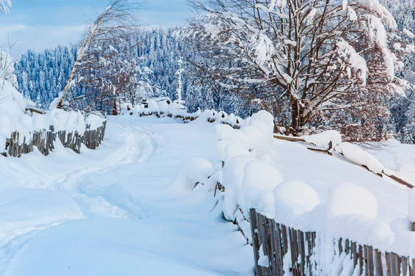Camino de nieve en pequeño pueblo en las montañas, paisaje de invierno. Concepto de lugar tranquilo —  Fotos de Stock