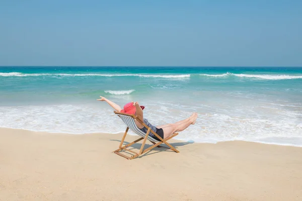 Szczęśliwa Kobieta w Czerwony Kapelusz przeciwsłoneczny na plaży — Zdjęcie stockowe