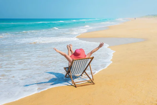 Счастливая женщина в красной солнечной шляпе на пляже — стоковое фото