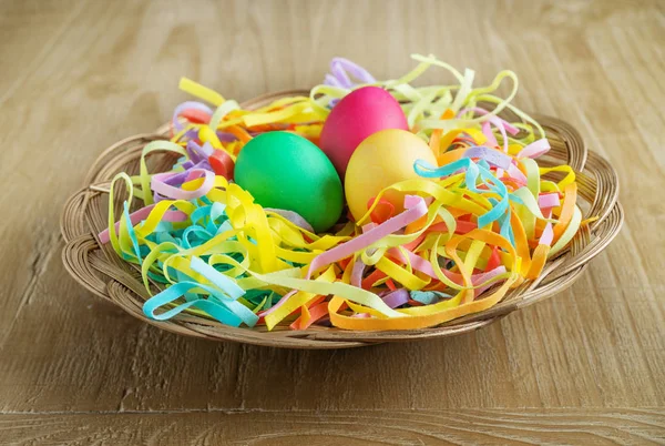 Huevos de Pascua multicolores en una cesta —  Fotos de Stock